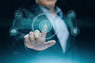 O persoană într-un costum întunecat atinge un ecran digital pe care apare o pictogramă cu un creier în centrul unor circuite luminoase.