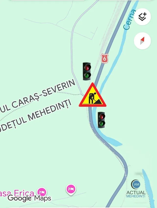 O hartă digitală prezintă un râu, o linie de drum, un semn de circulație triunghiular cu pictograma de lucrări și două semafoare.