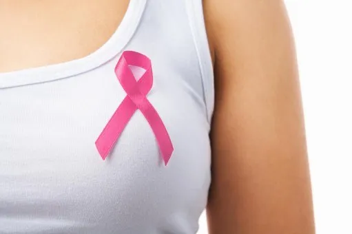 O persoană poartă un tricou alb pe care este aplicată o panglică roz.