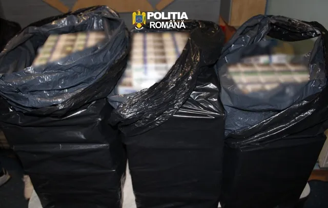 Trei saci negri de plastic deschiși conțin cutii de țigări așezate în rânduri.