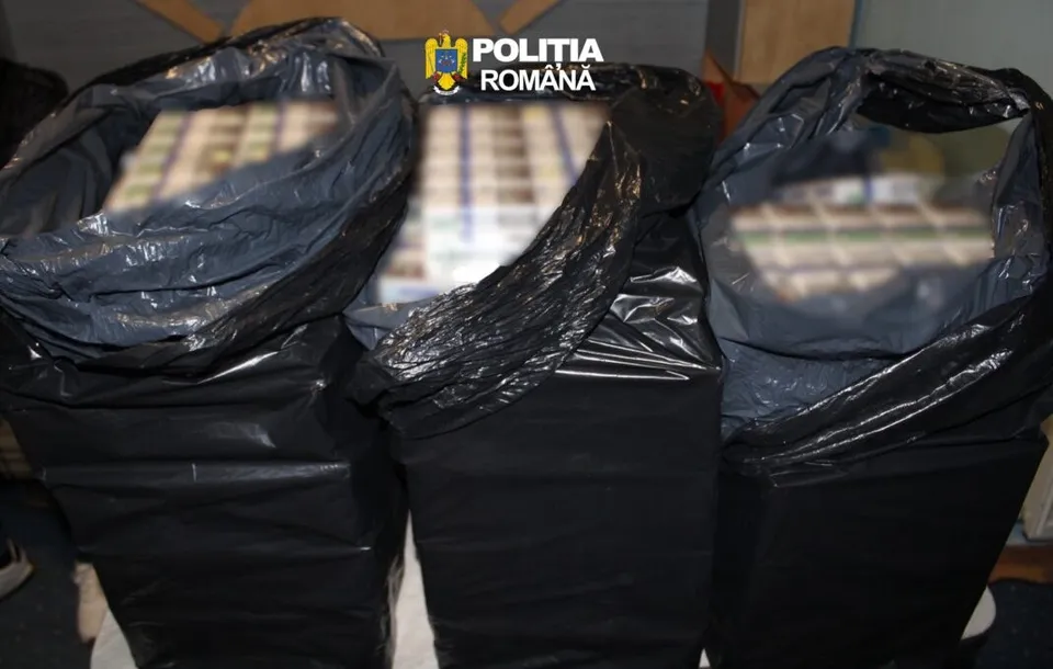 Trei saci negri de plastic deschiși conțin cutii de țigări așezate în rânduri.