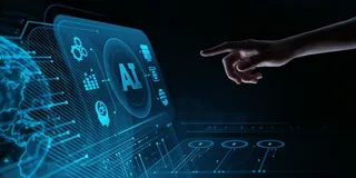 O mână întinsă spre un ecran digital albastru care afișează simboluri tehnologice, grafice și textul AI pe un fundal întunecat.