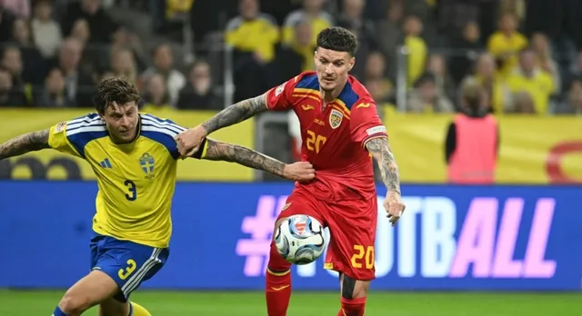 Un jucător în echipament galben și albastru dispută un balon cu un jucător în echipament roșu pe un teren de fotbal.