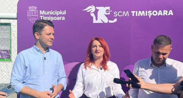 Trei persoane stau în fața unui panou violet pe care sunt afișate logourile Municipiului Timișoara și SCM Timișoara, în timp ce unul dintre ei ține un microfon.