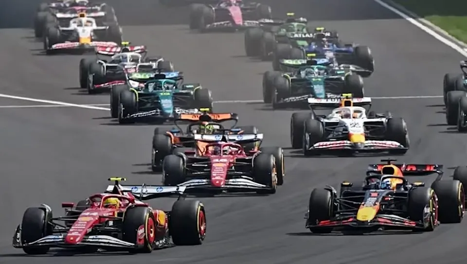 Mai mulți piloți conduc mașini de Formula 1 pe un circuit de curse asfaltat.