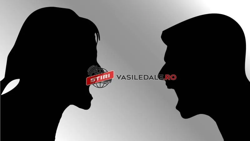 Două siluete negre de profil, una feminină și una masculină, sunt poziționate față în față pe un fundal gri gradat.