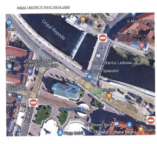 O hartă satelitară a unei zone urbane cu un râu, poduri, străzi, clădiri și diverse marcaje grafice de trafic suprapuse.