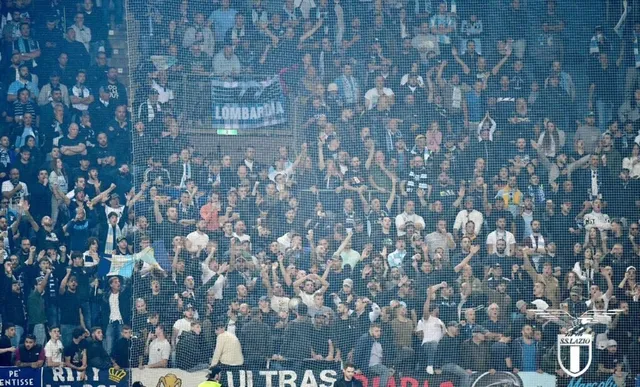 O mulțime de suporteri se adună în tribună, unii ridicând brațele și flând steaguri albastre și negre, într-un stadion de fotbal.