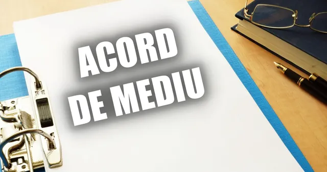 Un dosar cu textul ACORD DE MEDIU este așezat pe o masă lângă ochelari, un stilou și o carte.