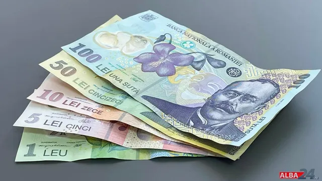 Bancnote românești de valori diferite sunt așezate suprapus pe o suprafață cenușie.