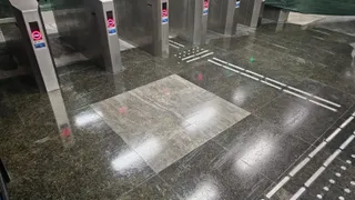 Mai multe turnușuri metalice de acces sunt instalate pe un podea de piatră lucioasă într-un spațiu interior.