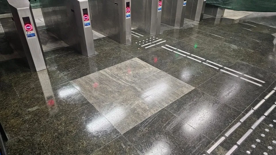 Mai multe turnușuri metalice de acces sunt instalate pe un podea de piatră lucioasă într-un spațiu interior.