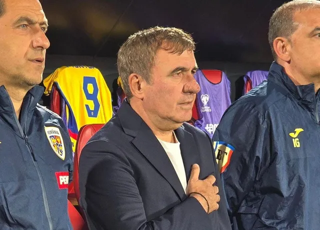 Trei bărbați stau unul lângă altul, cel din mijloc purtând un sacou albastru și un tricou alb, cu mâna pe piept.