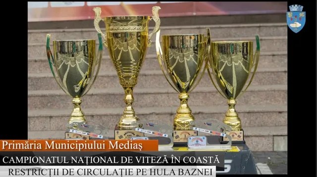 Patru trofee aurii sunt așezate pe un suport pe trepte de piatră.