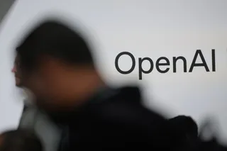 Un logo cu textul OpenAI este afișat pe un fundal alb lângă silueta neclară a unei persoane.