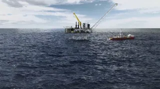 O platformă petrolieră cu o macara galbenă și o navă de lucru navighează pe o suprafață de apă sub un cer înnorat.