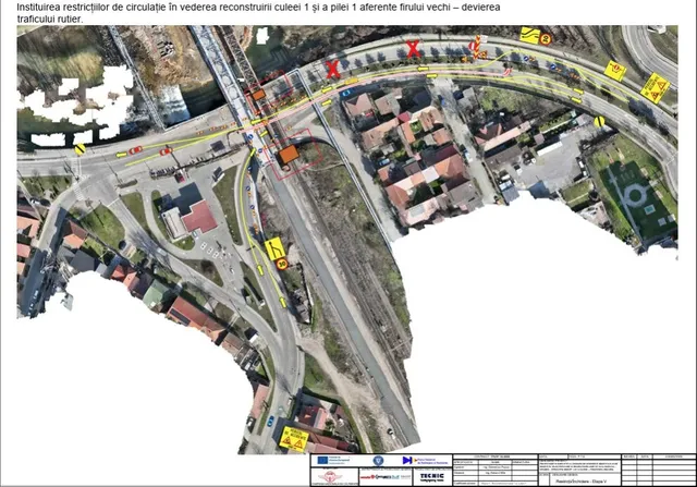 O hartă aeriană a unei zone urbane cu căi ferovare, linii galbene și marcaje roșii indicând trasee și restricții de circulație pe drumurile asfaltate.
