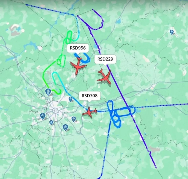 O hartă cu trasee de zbor colorate și pictograme de avioane roșii marcate cu coduri de zbor pe un fundal de teren verde.