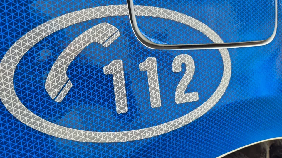 Un simbol al telefonului și numărul 112 sunt imprimate pe o suprafață albastră cu textură reflectorizantă.