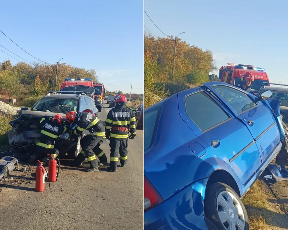 Pompieri în echipament de protecție portocaliu și negru lucrează lângă două autoturisme avariate pe un drum asfaltat sub un cer senin.