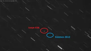 O imagine radar cu fundal negru arătând urme liniare albe de stele sau sateliți, cu două cercuri colorate (roșu și albastru) care marchează pozițiile sateliților Iceye-X36 și Kosmos 2612.