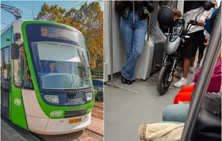Un tramvai verde și alb circulă pe șine, iar în interior se observă un scuter gri situat pe podeaua vehiculului lângă pasageri.