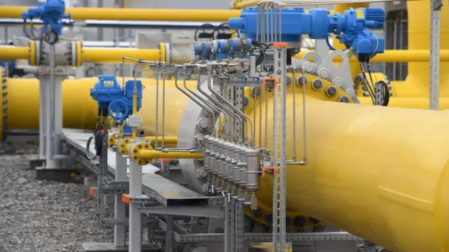 Conducte galbene de dimensiuni mari sunt conectate prin robinete și dispozitive metalice de control într-o stație industrială de utilități.