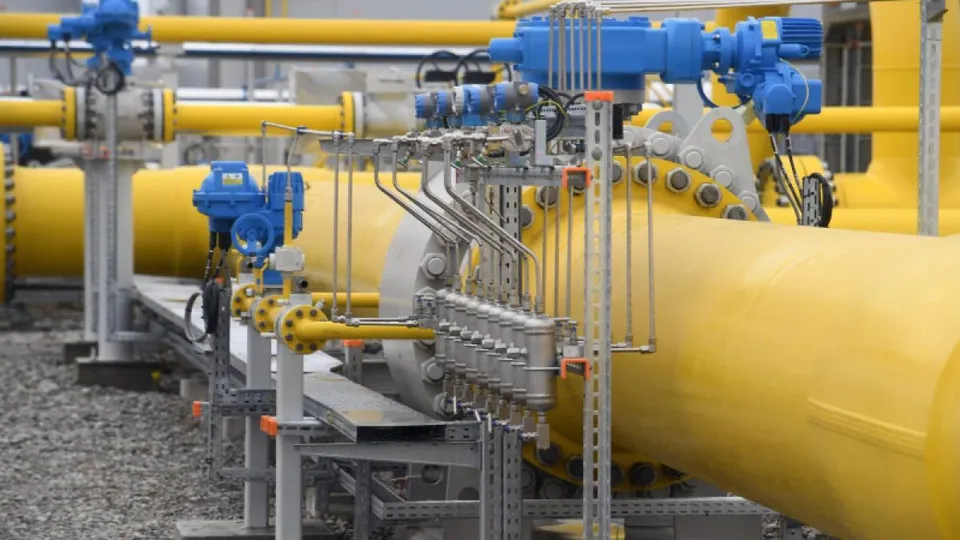 Conducte galbene de dimensiuni mari sunt conectate prin robinete și dispozitive metalice de control într-o stație industrială de utilități.