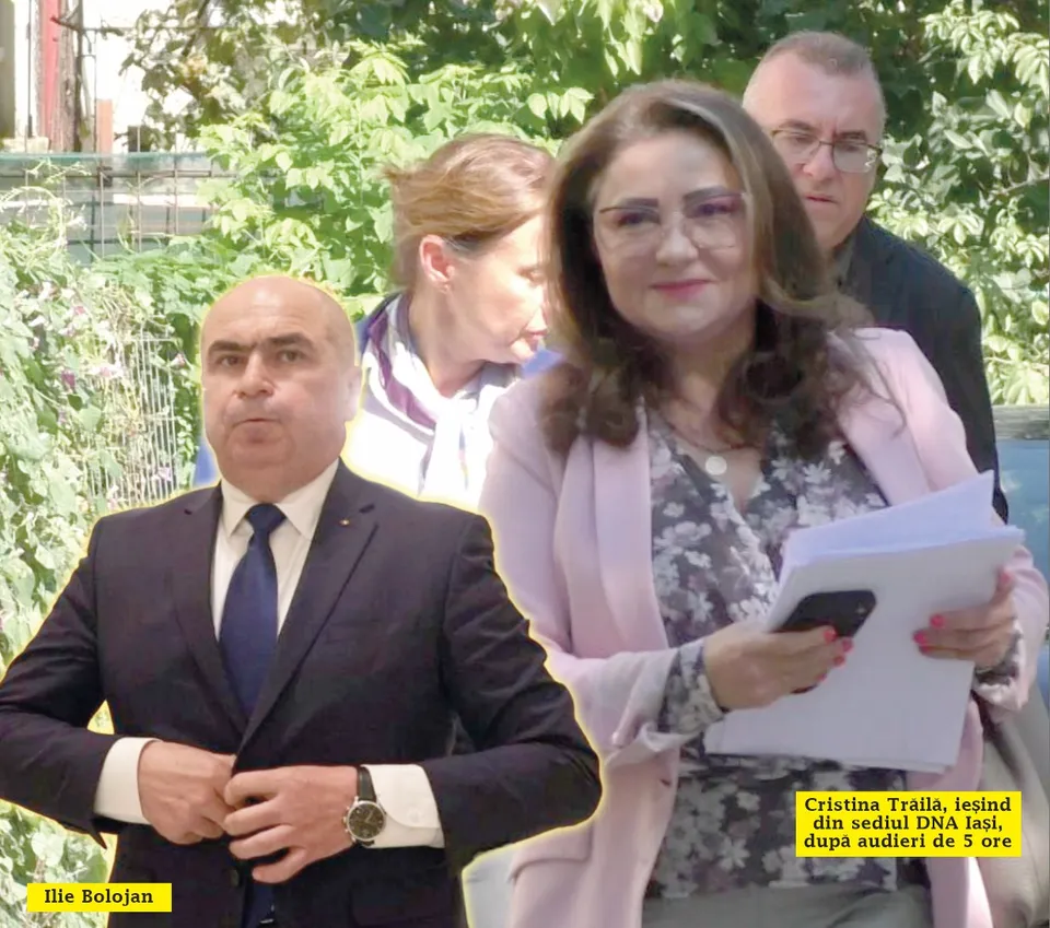 O femeie cu ochelari și sacou roz ține foi albe, în timp ce un bărbat într-un costum închis stă în prim-plan.