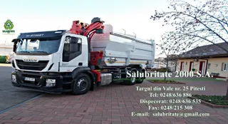 Un camion alb de serviciu este parcat pe o suprafață pavată lângă un clădire și un copac sub un cer deschis.