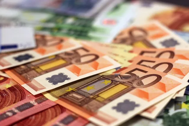 Bancnote euro de valori diferite, așezate suprapus pe o suprafață.
