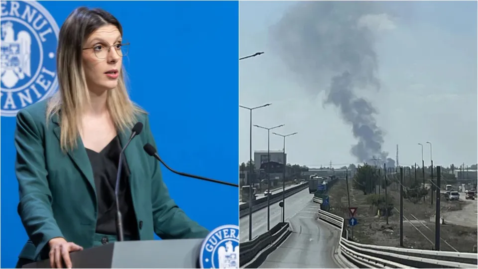 O femeie cu ochelari poartă un sacou verde și vorbește la un microfon, în timp ce în partea dreaptă se vede fum negru deasupra unui peisaj urban.