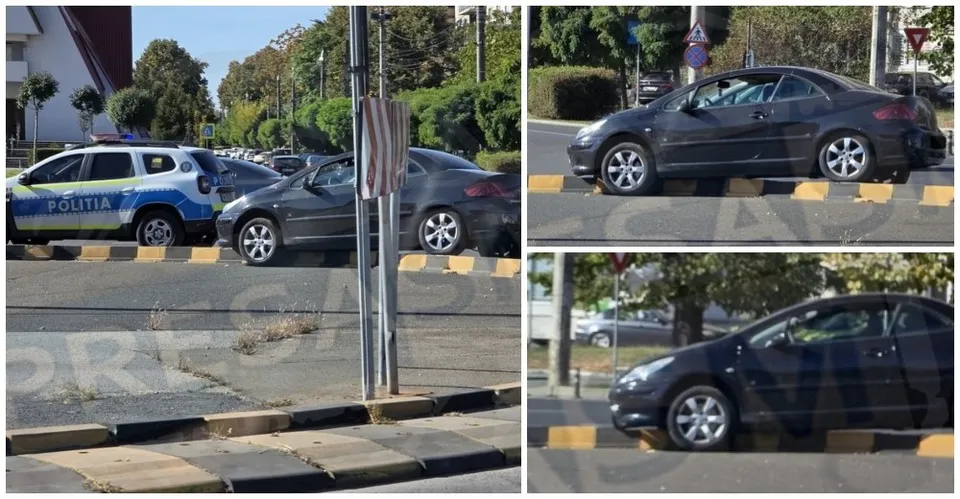 Un autoturism negru este poziționat pe bordura unei insule de separare, lângă un vehicul de poliție albastru și alb.