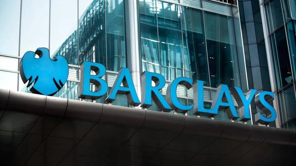 Un semn albastru cu textul BARCLAYS și un logo în formă de păsare este montat pe fațada unei clădiri de sticlă.