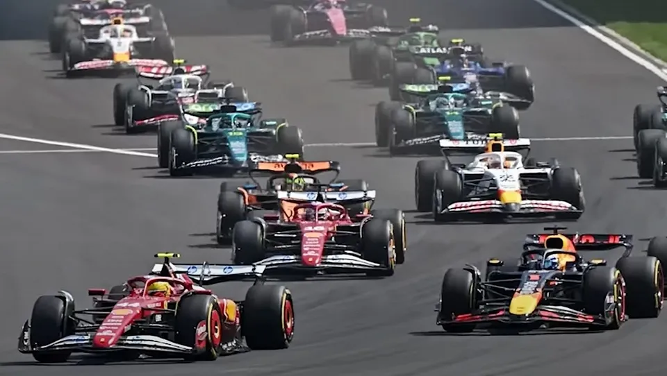 Mai mulți piloți conduc mașini de Formula 1 pe un circuit de curse asfaltat.
