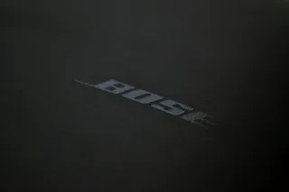 Logo-ul cu textul BOSE este imprimat pe o suprafață neagră, texturată și mată.