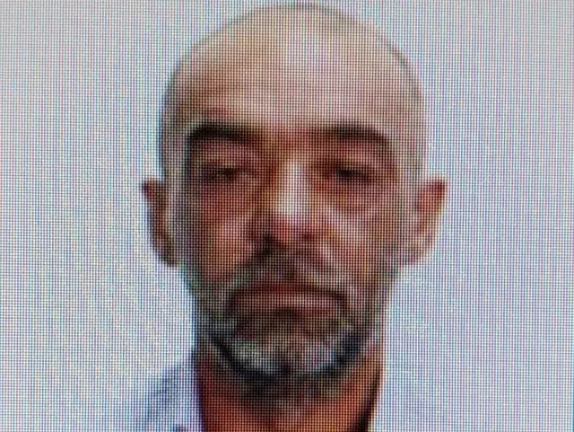Un bărbat cu părul scurt și barbă căruntă este surprins într-o fotografie de tip portret cu fundal neutru.