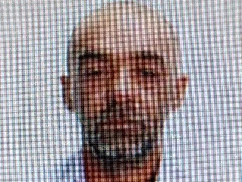 Un bărbat cu părul scurt și barbă căruntă este surprins într-o fotografie de tip portret cu fundal neutru.