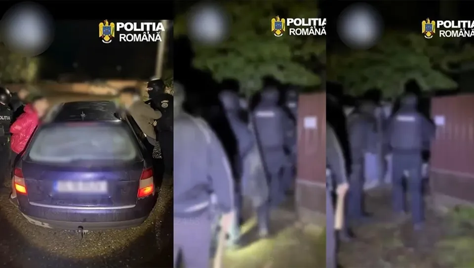 O mașină închisă la culoare este parcată pe un drum, în timp ce mai mulți oameni în uniformă stau în apropiere pe timp de noapte.