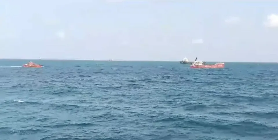 Trei nave mici navighează pe o suprafață de apă de culoare albastru-închis sub un cer deschis și luminos.