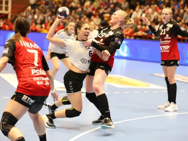 Câteva jucătoare de handbal în echipamente de sport roșu, negru și alb participă la un meci pe un teren de culoare albastră.