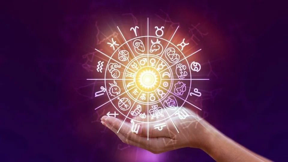O mână întinsă susține un simbol circular strălucitor cu diverse embleme astrologice pe un fundal violet.