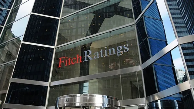 O clădire modernă cu fațadă de sticlă prezintă un logo cu textul Fitch Ratings aplicat pe suprafața transparentă.