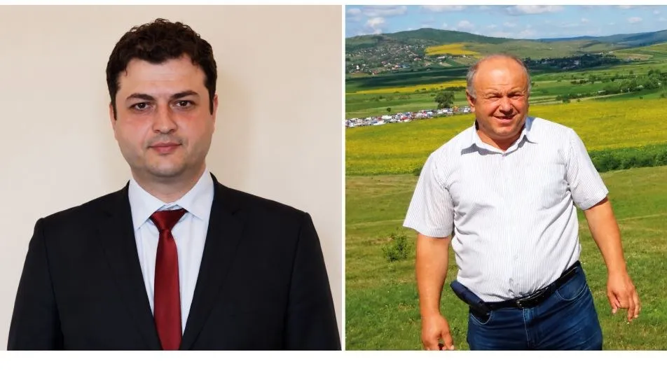 Un bărbat poartă costum negru cu cravată roșie, iar lângă acesta un alt bărbat poartă cămașă albă și blugi în fața unui peisaj verde.