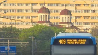 Partea din spate a unui autobuz albastru afișează numărul 409 și textul Bucur Obor Merii Petchii sub două cupole de culoare roșie.