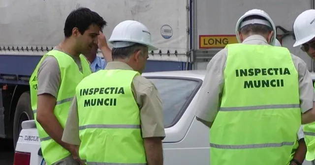 Patru bărbați poartă veste reflectorizante galben-verzui, dintre acestea două având inscripția Inspectia Muncii, stând lângă un vehicul alb.
