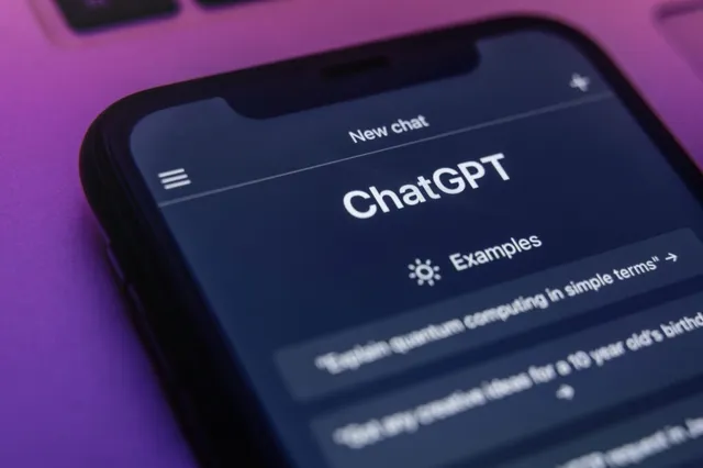 Un smartphone afișează interfața aplicației ChatGPT pe un fundal violet.