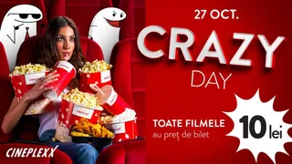 O femeie stă în fotoliul de cinema cu mai multe cutii de popcorn și băuturi răcoritoare pe lângă ea.