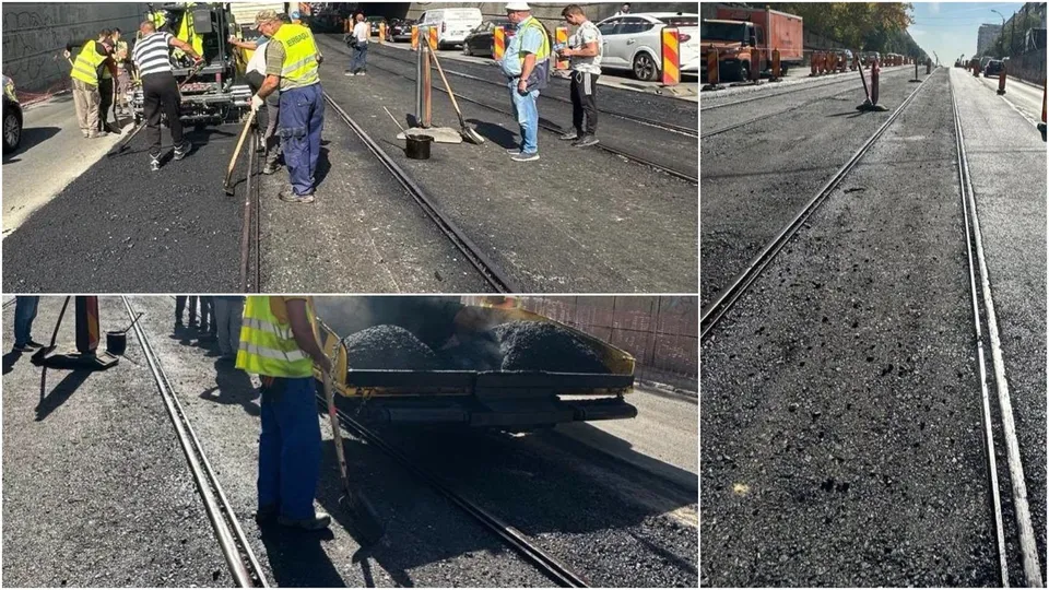 O echipă de lucrători în veste reflectorizante toarnă asfalt pe o suprafață între două șine de tramvai sub lumina soarelui.
