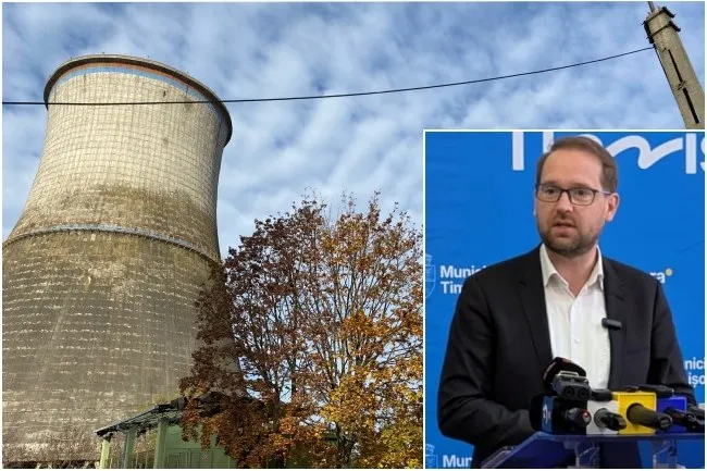 O turnare de răcire de beton se ridică lângă un copac cu frunze galbene, în timp ce un bărbat cu ochelari stă în fața unor microfoane.